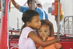 Nasir Penix,7, holds her brother Makey, 2, on a kiddie ride at the fair Tuesday evening.