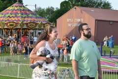 Rockelle and Cameron Ward walk through the carnival after winning a stuffed elephant at a game on the midway Tuesday night. Rockell said they are having a baby girl in September and the nursery is decorated with elefants.