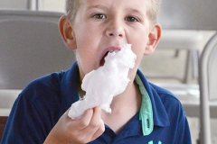 Ayden Davis, 8, of Harrodsburg, stuffs his mouth with cotton candy Wednesday night at the fair.